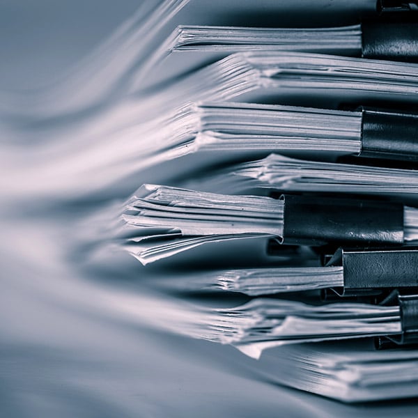 Stack of binder-clipped documents